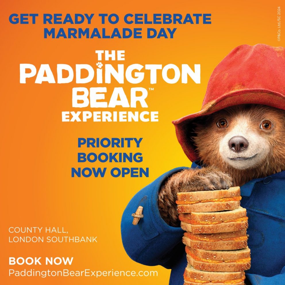 Promotional image for The Paddington Bear experience with Paddington Bear holding a stack of marmalade sandwiches.