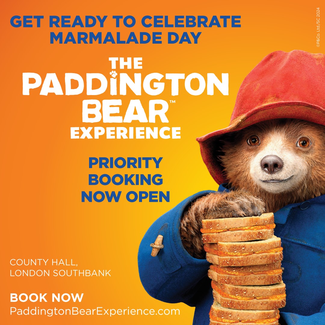 Promotional image for The Paddington Bear experience with Paddington Bear holding a stack of marmalade sandwiches.
